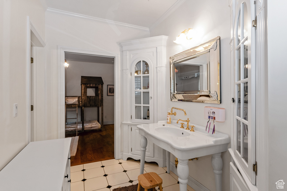 Bathroom featuring hardwood / wood-style flooring and ornamental molding