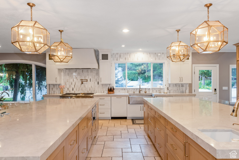 Kitchen with a spacious island, decorative light fixtures, and tasteful backsplash