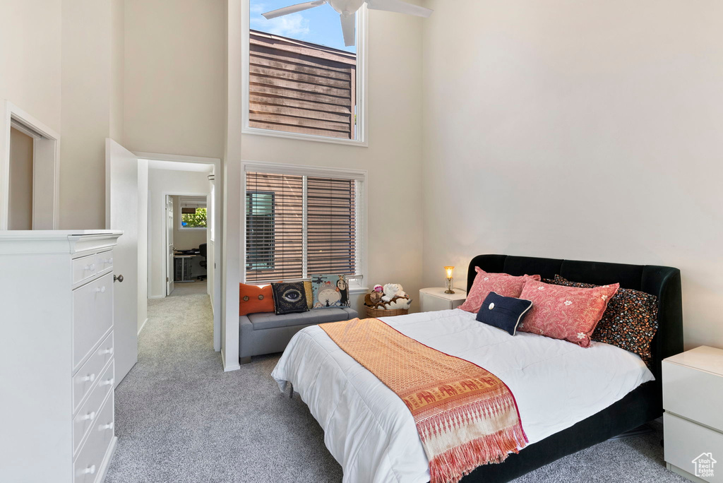 Bedroom featuring a high ceiling and light colored carpet