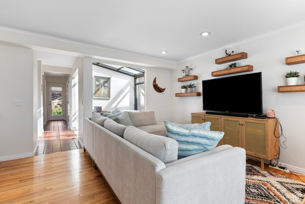 Living room featuring crown molding and light hardwood / wood-style flooring