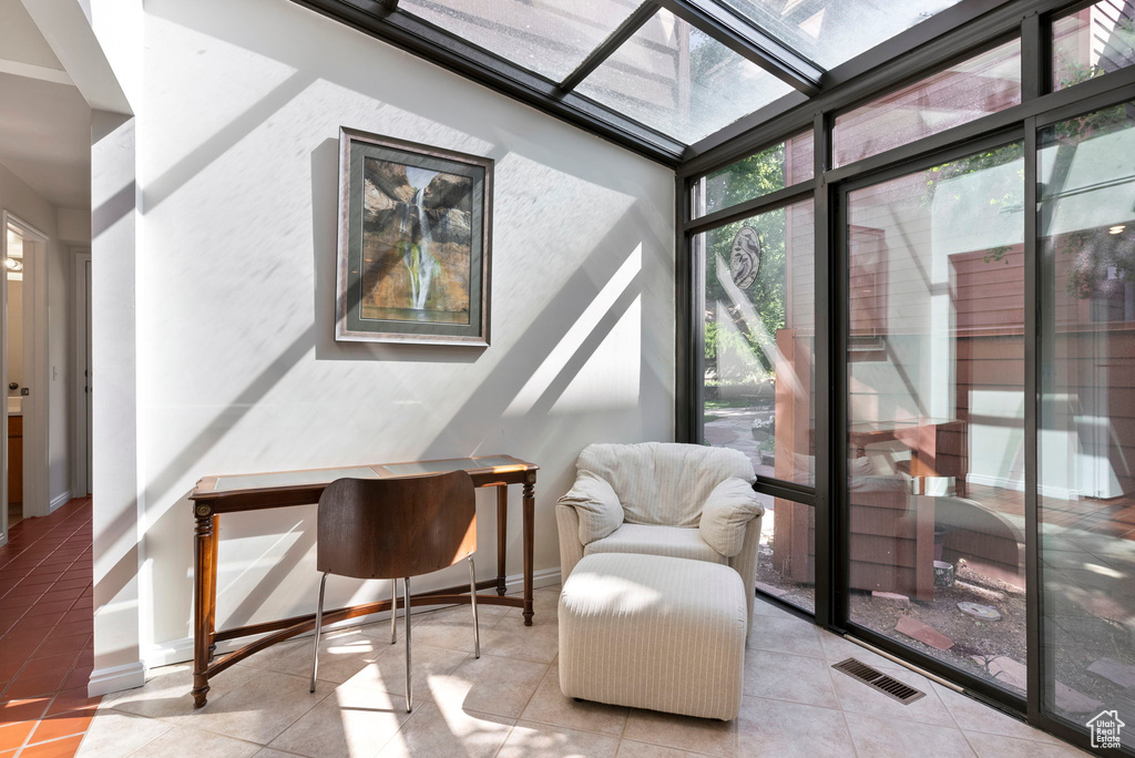 Sitting room featuring light tile patterned flooring, a skylight, and a wealth of natural light