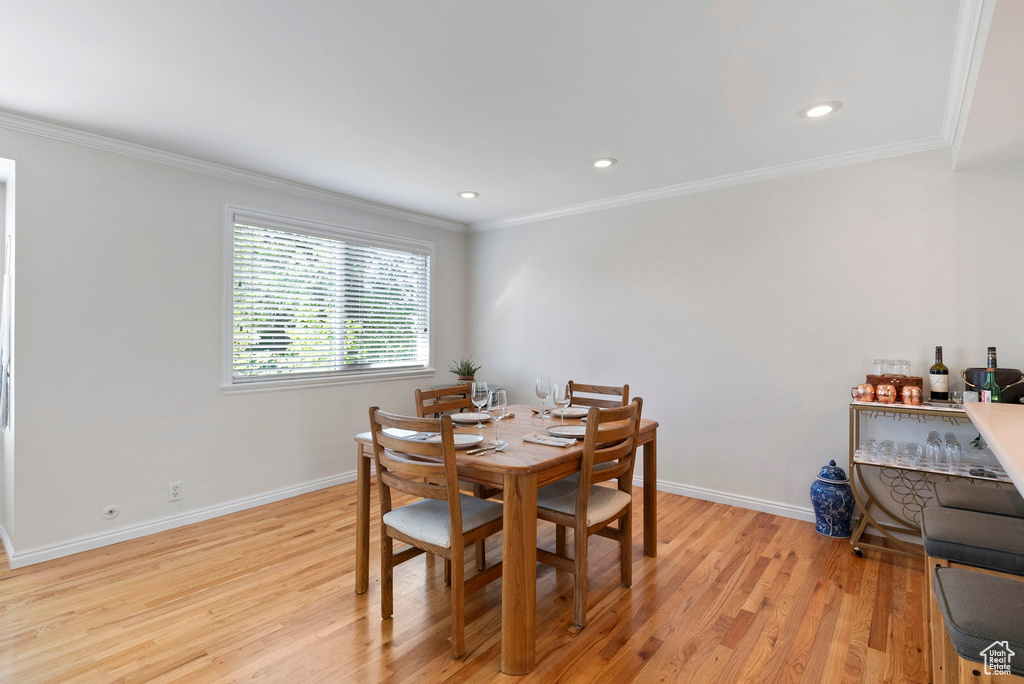 Dining space featuring light hardwood / wood-style floors and crown molding