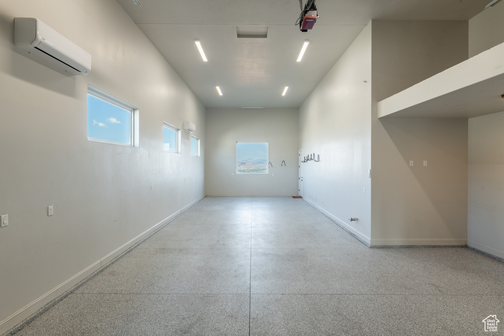 Empty room with an AC wall unit and a towering ceiling