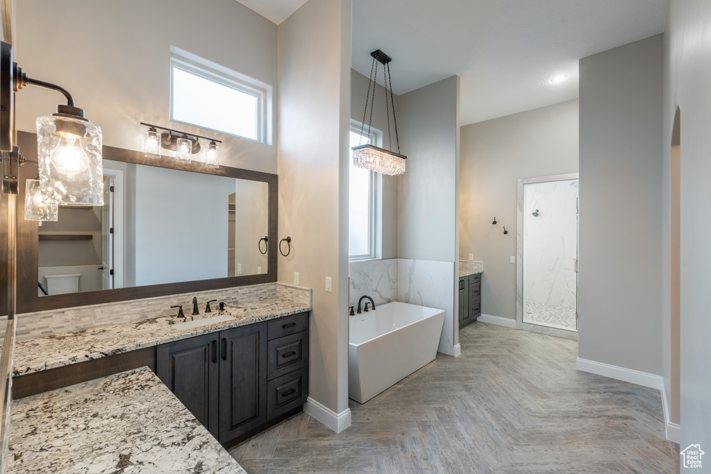 Bathroom with independent shower and bath, vanity, and parquet flooring