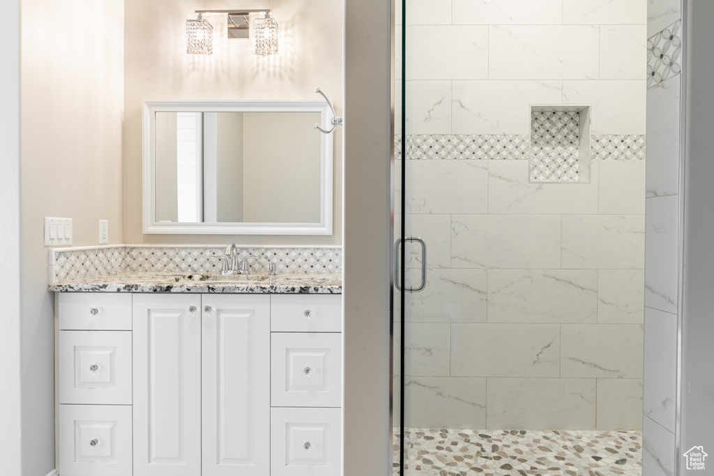 Bathroom with a shower with shower door and vanity