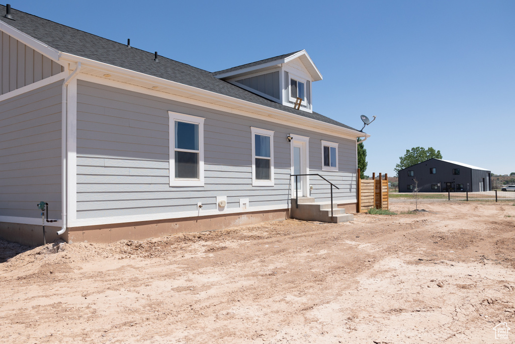 Rear view of house with a shingled roof