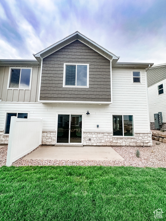 Back of property with a yard and a patio area