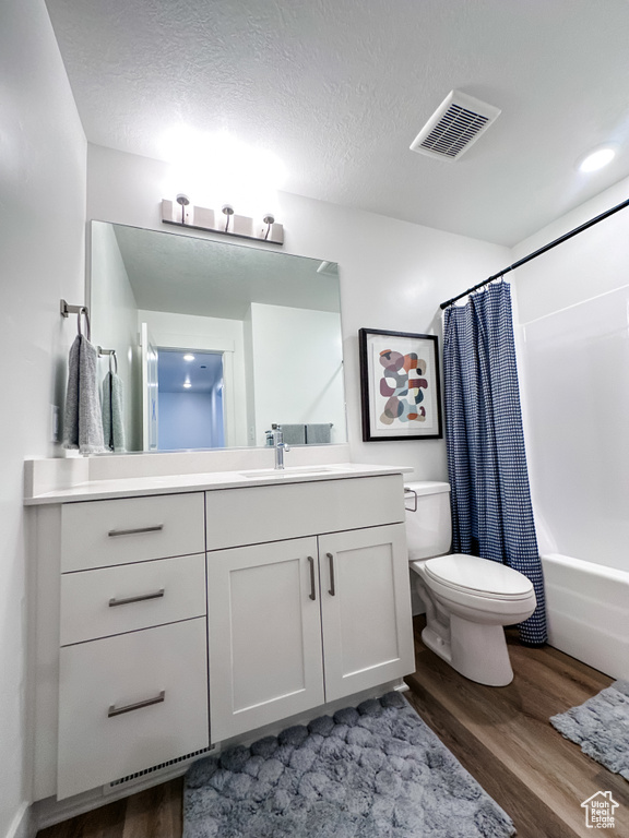 Full bathroom featuring shower / tub combo, wood-type flooring, toilet, and vanity