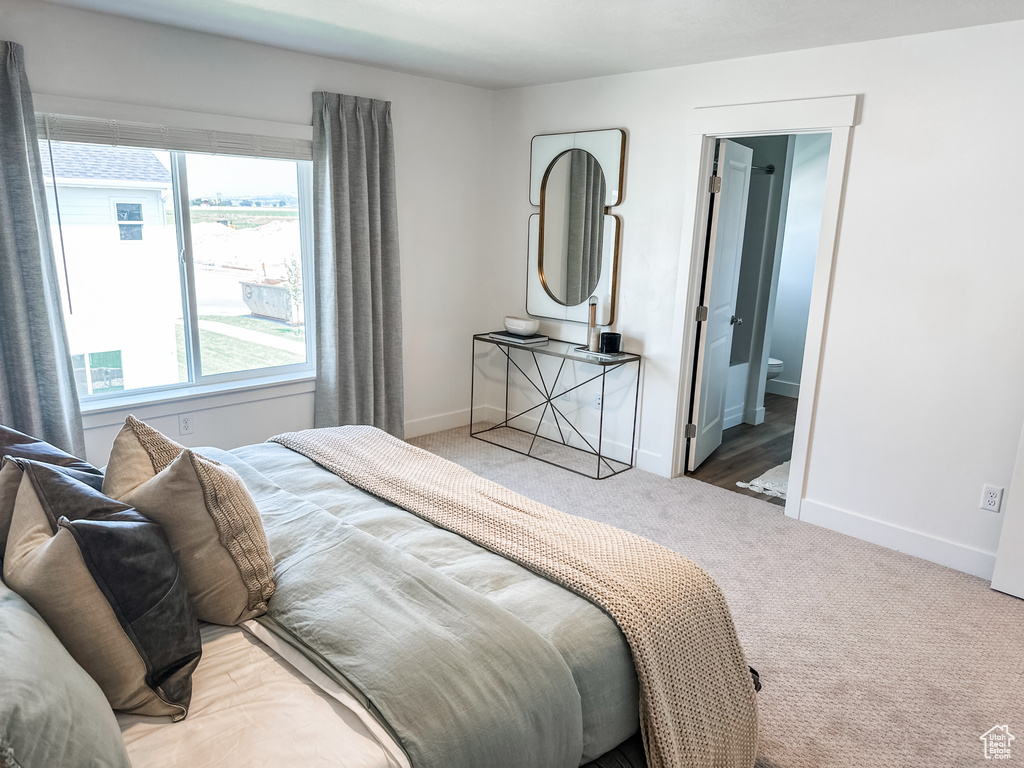 Carpeted bedroom featuring ensuite bathroom