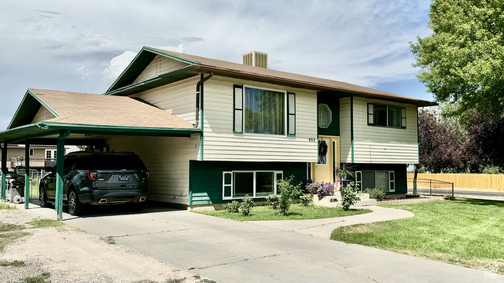 Raised ranch featuring a carport and a front lawn