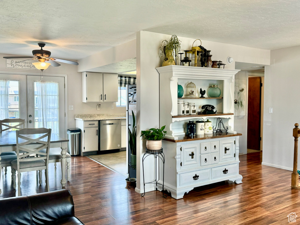 Kitchen featuring appliances with stainless steel finishes, dark wood-type flooring, and white cabinets