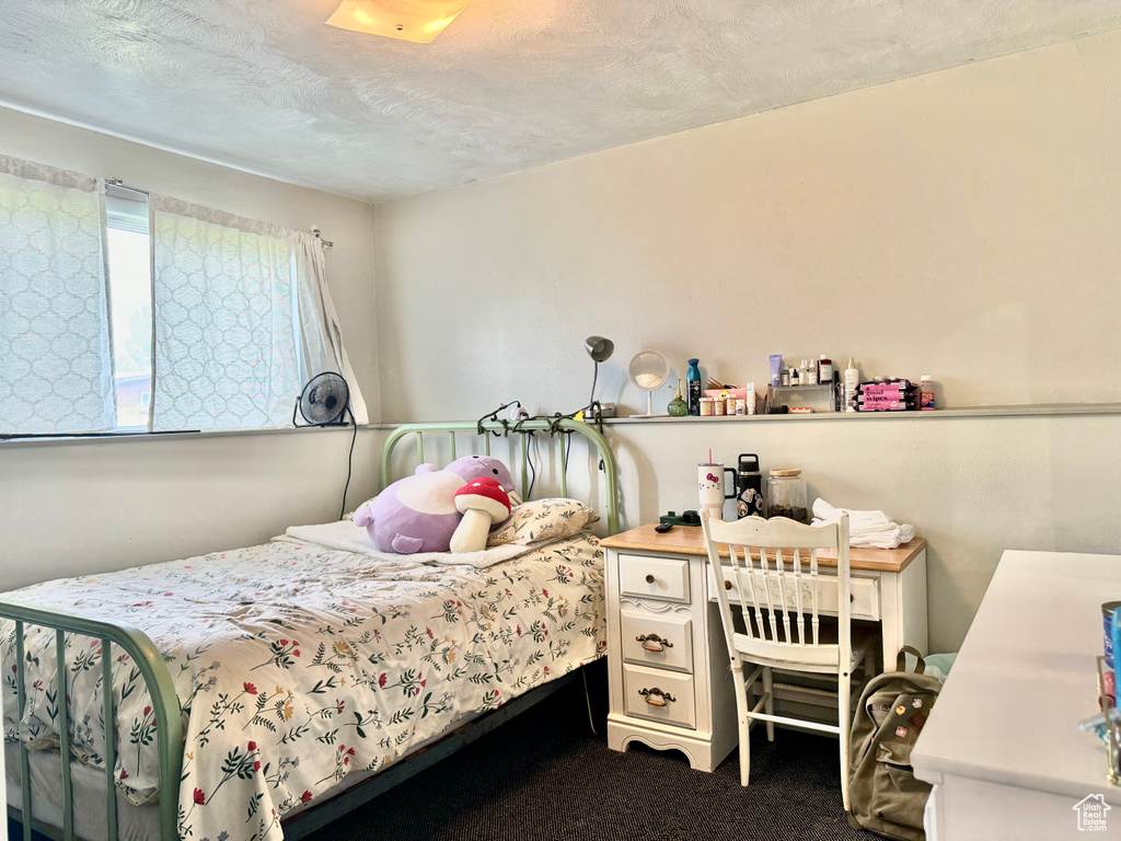 Bedroom with carpet floors and a textured ceiling