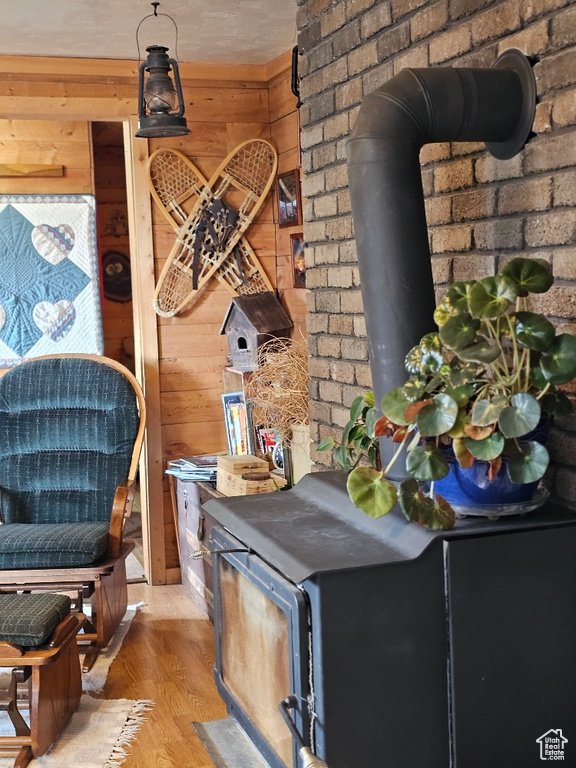 Room details with wood walls, hardwood / wood-style flooring, and a wood stove