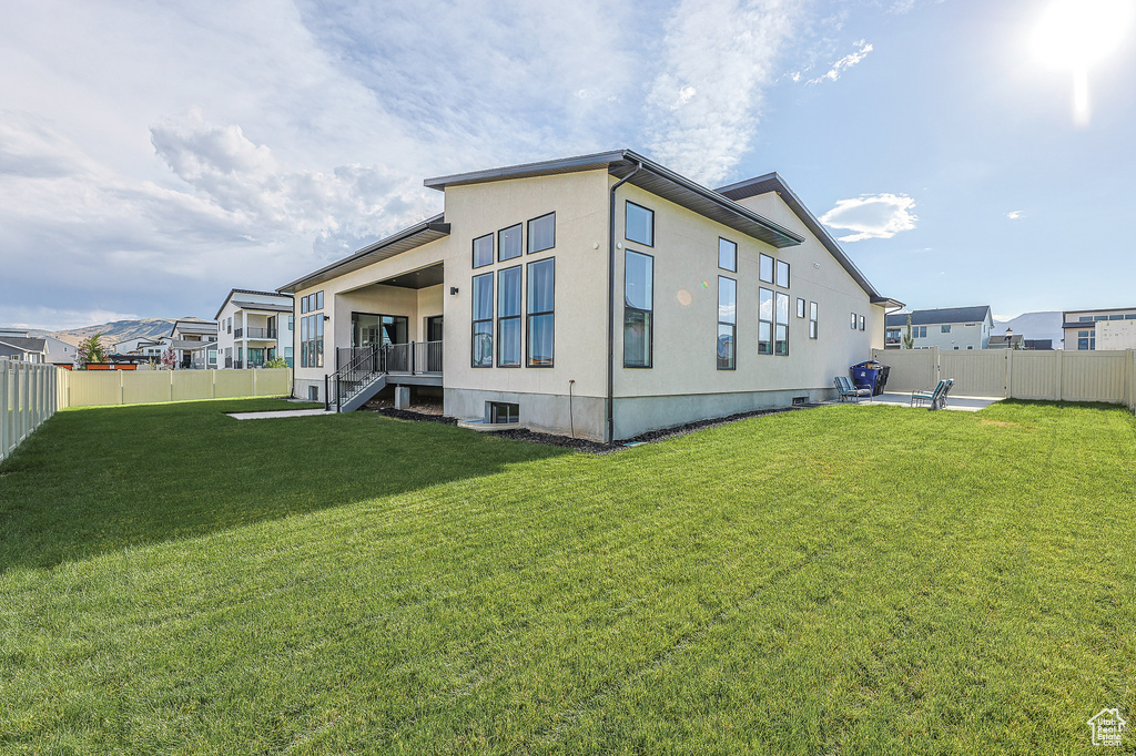 Rear view of property with a yard