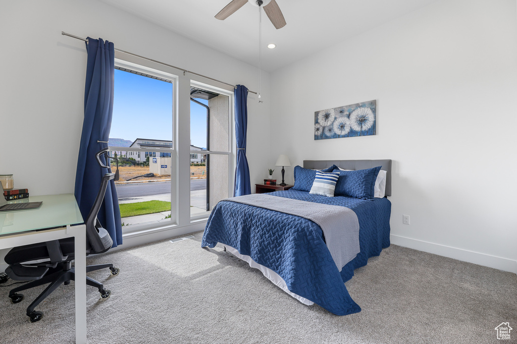 Carpeted bedroom featuring ceiling fan