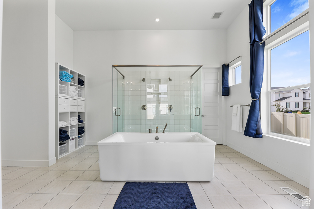 Bathroom featuring shower with separate bathtub and tile patterned floors