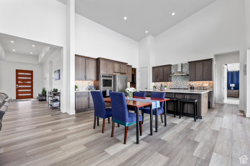 Dining space featuring light hardwood / wood-style floors and a towering ceiling