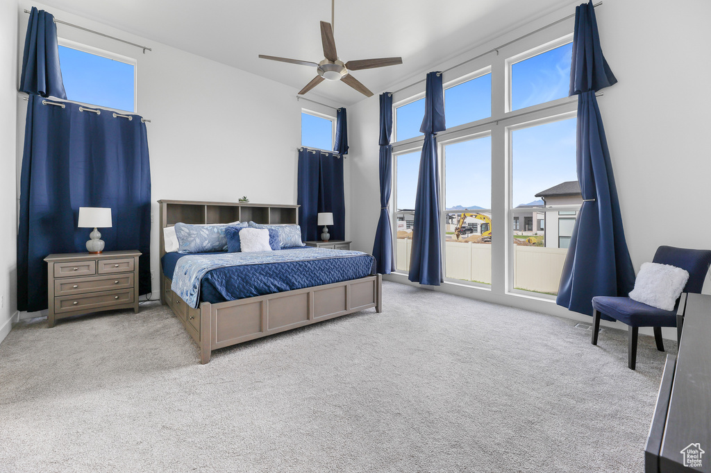 Carpeted bedroom featuring ceiling fan