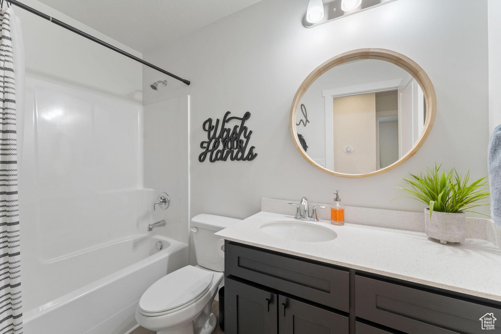 Full bathroom featuring vanity, shower / bathtub combination with curtain, and toilet