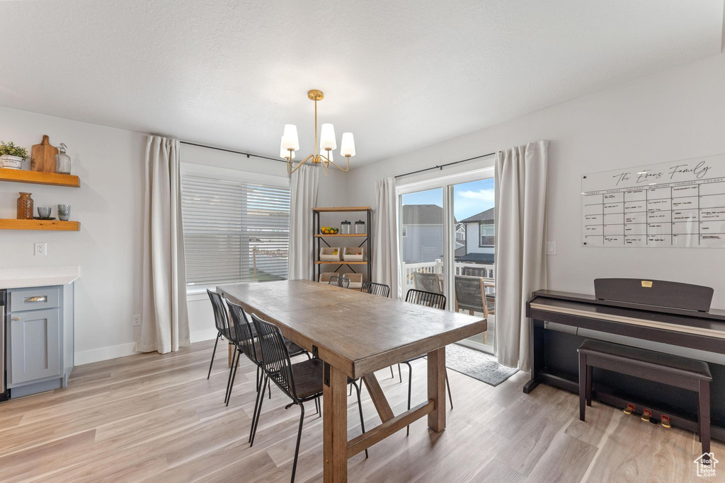 Dining space featuring light wood-type flooring and an inviting chandelier