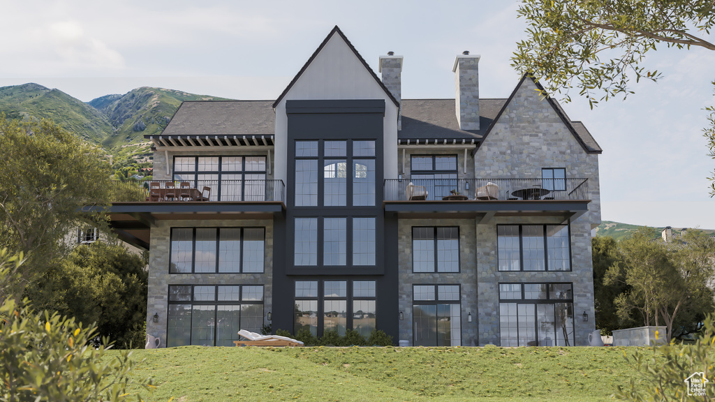 Back of property featuring a mountain view and a balcony