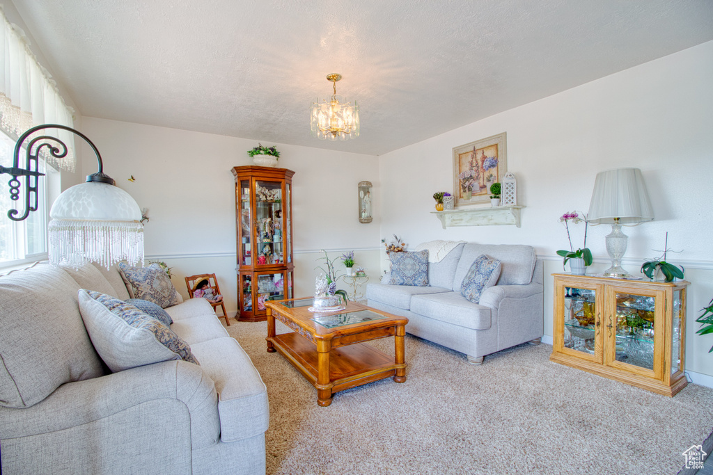 Carpeted living room with an inviting chandelier