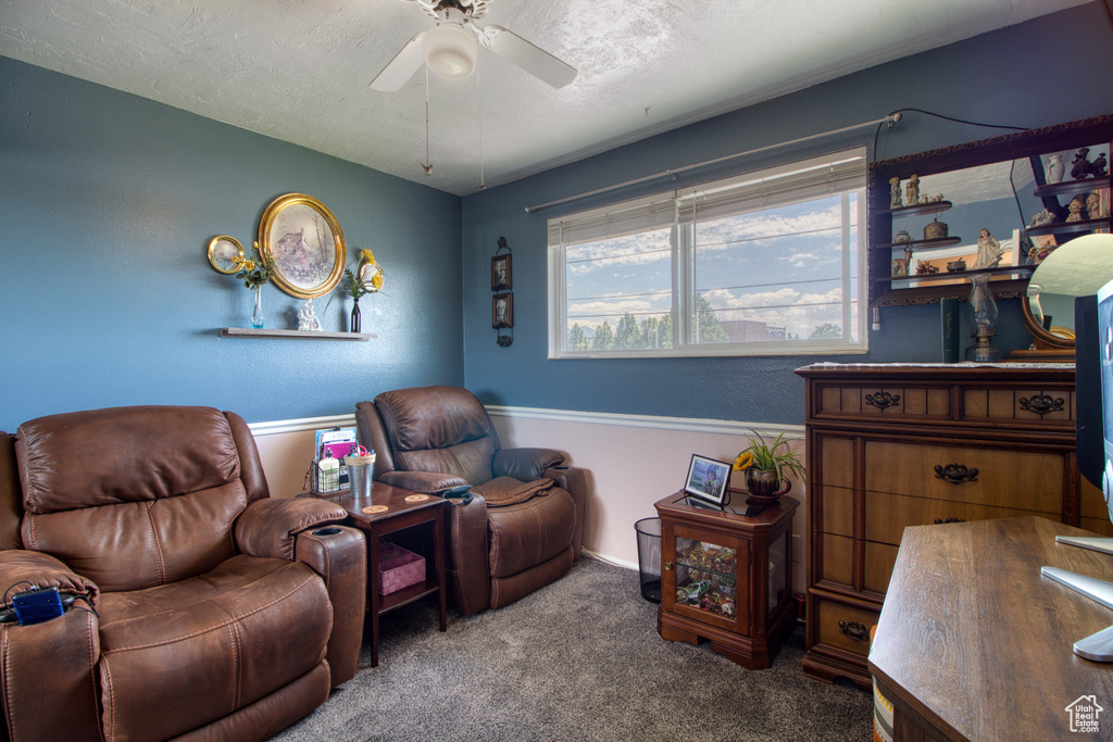 Living room with carpet floors, a textured ceiling, and ceiling fan