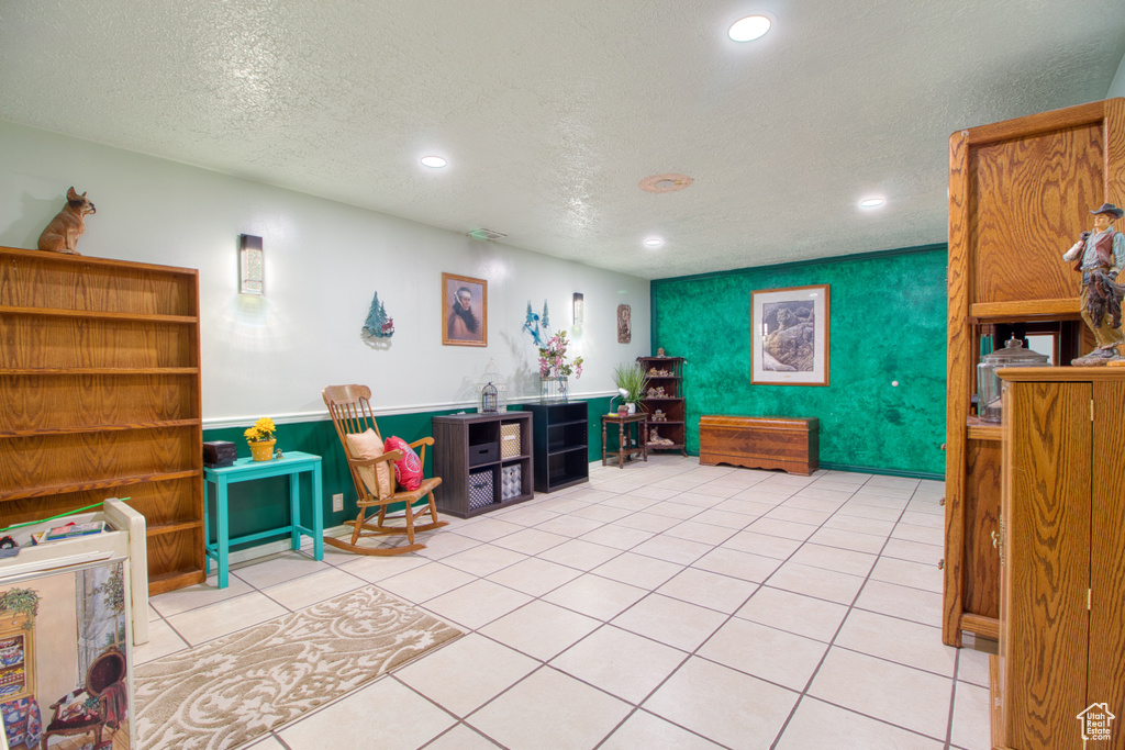 Interior space featuring a textured ceiling and light tile patterned floors