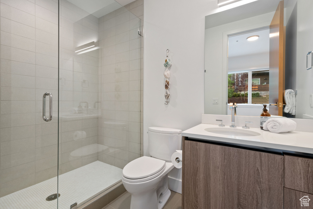 Bathroom with vanity, walk in shower, and toilet