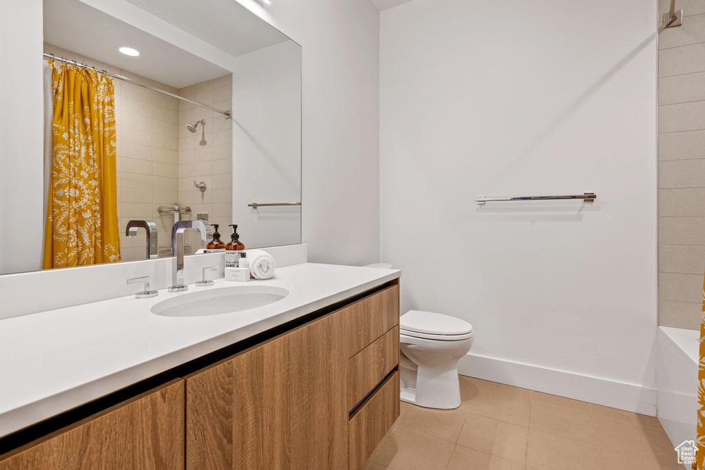 Full bathroom featuring vanity, shower / bathtub combination with curtain, tile patterned flooring, and toilet