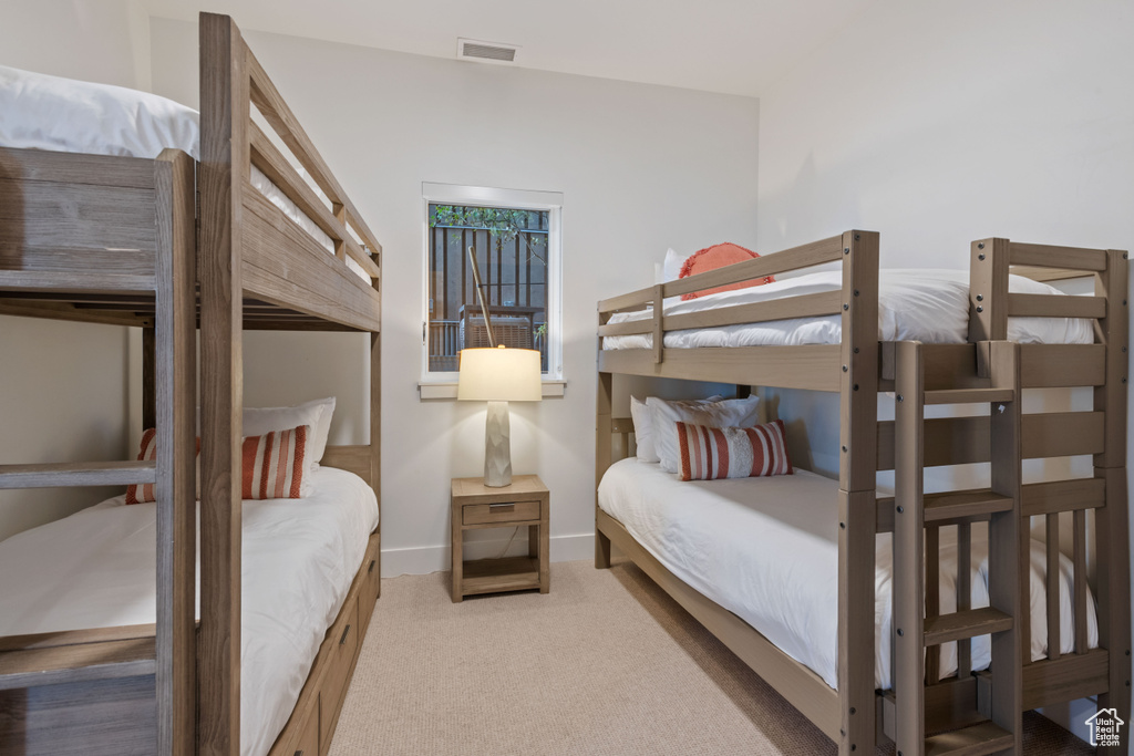 Bedroom featuring light carpet