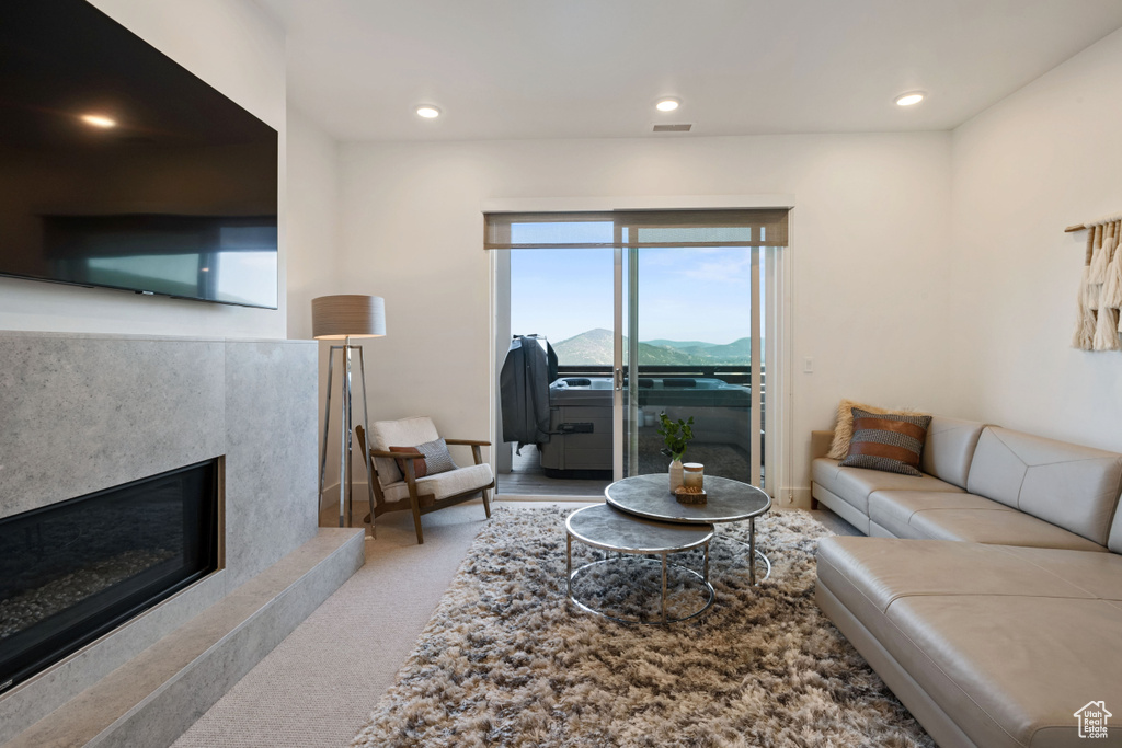 Living room featuring carpet floors and a high end fireplace