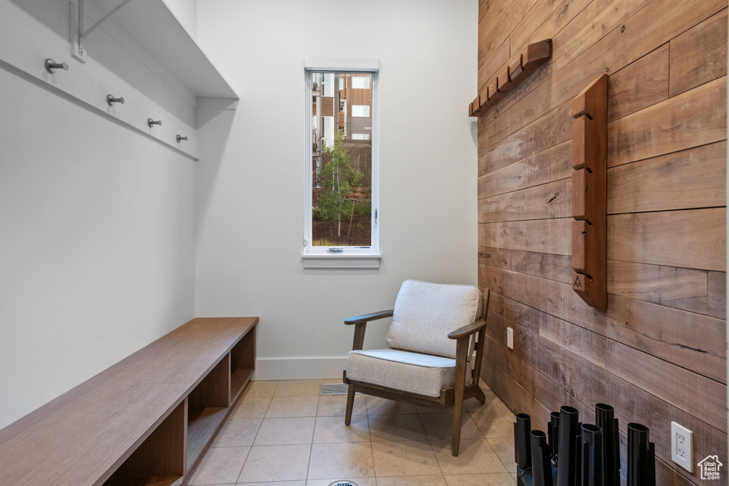 Mudroom with wood walls and light tile patterned floors