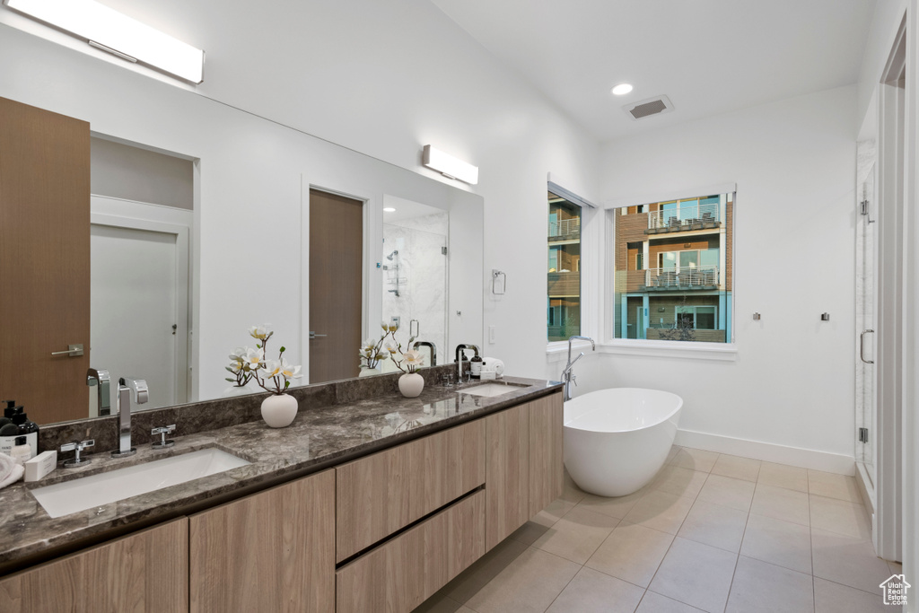 Bathroom featuring dual vanity, tile patterned floors, and separate shower and tub