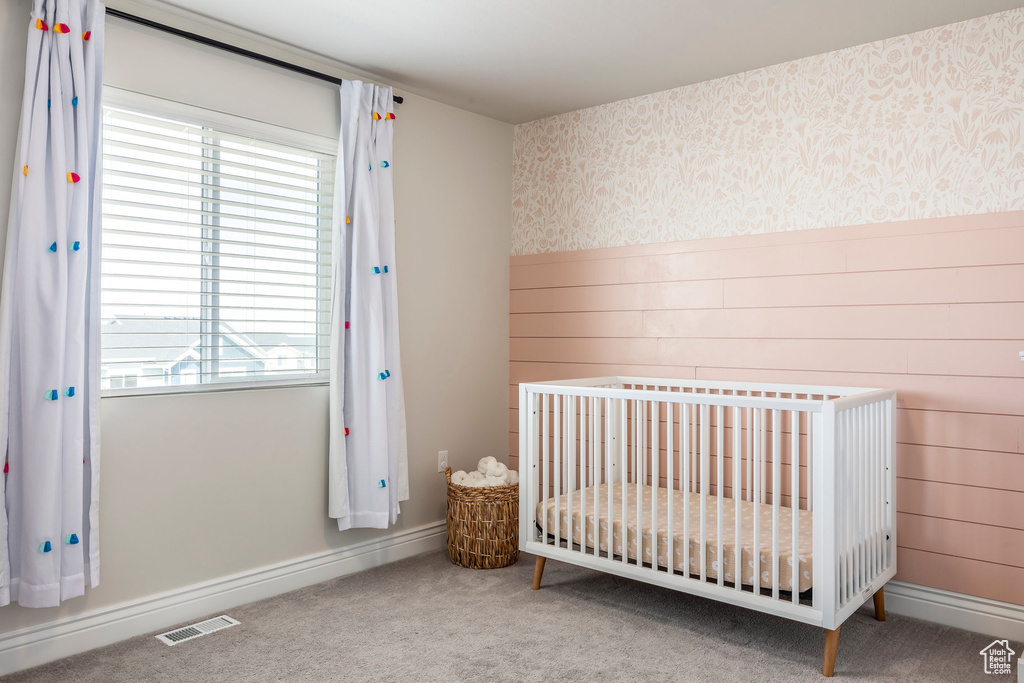 Bedroom with carpet and a nursery area