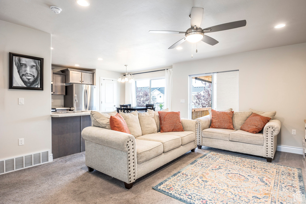 Carpeted living room featuring ceiling fan