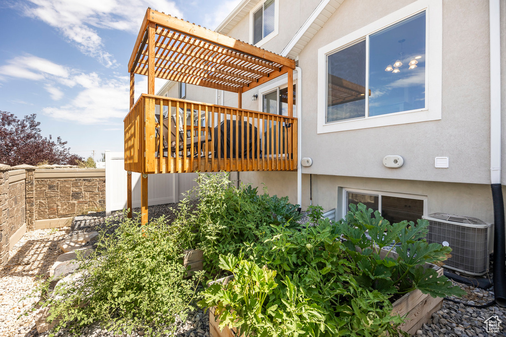 View of property exterior featuring a deck, central air condition unit, and a pergola