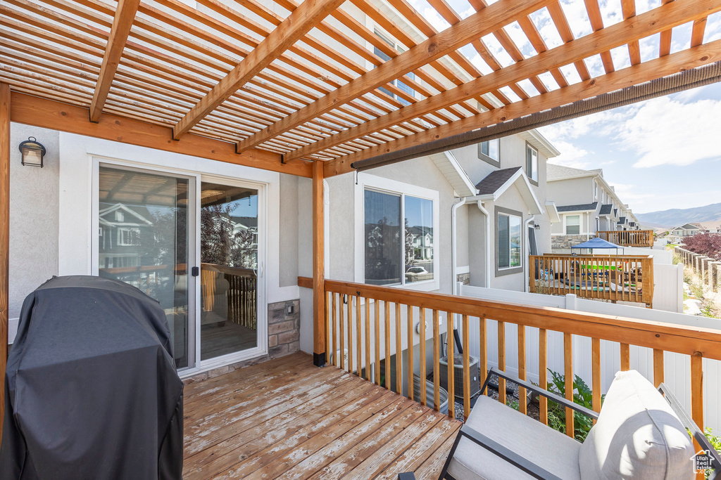 Wooden terrace featuring a pergola and a grill