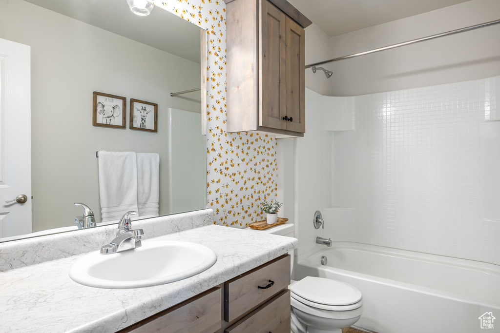 Full bathroom featuring vanity, toilet, and  shower combination