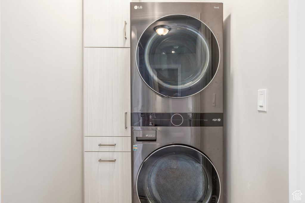 Clothes washing area with cabinets and stacked washer / drying machine