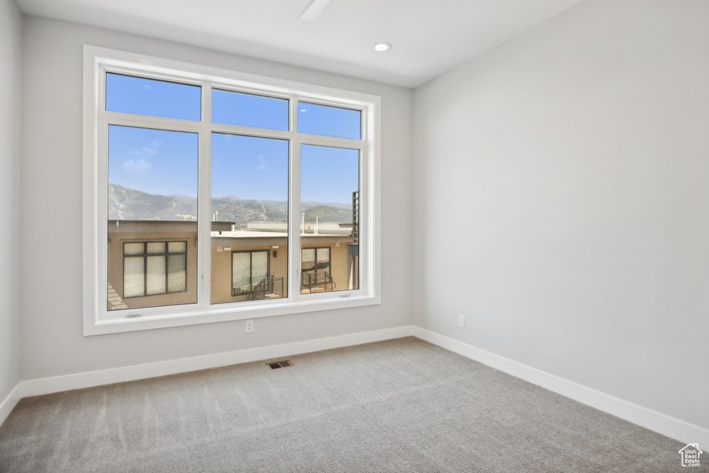 Carpeted empty room featuring plenty of natural light