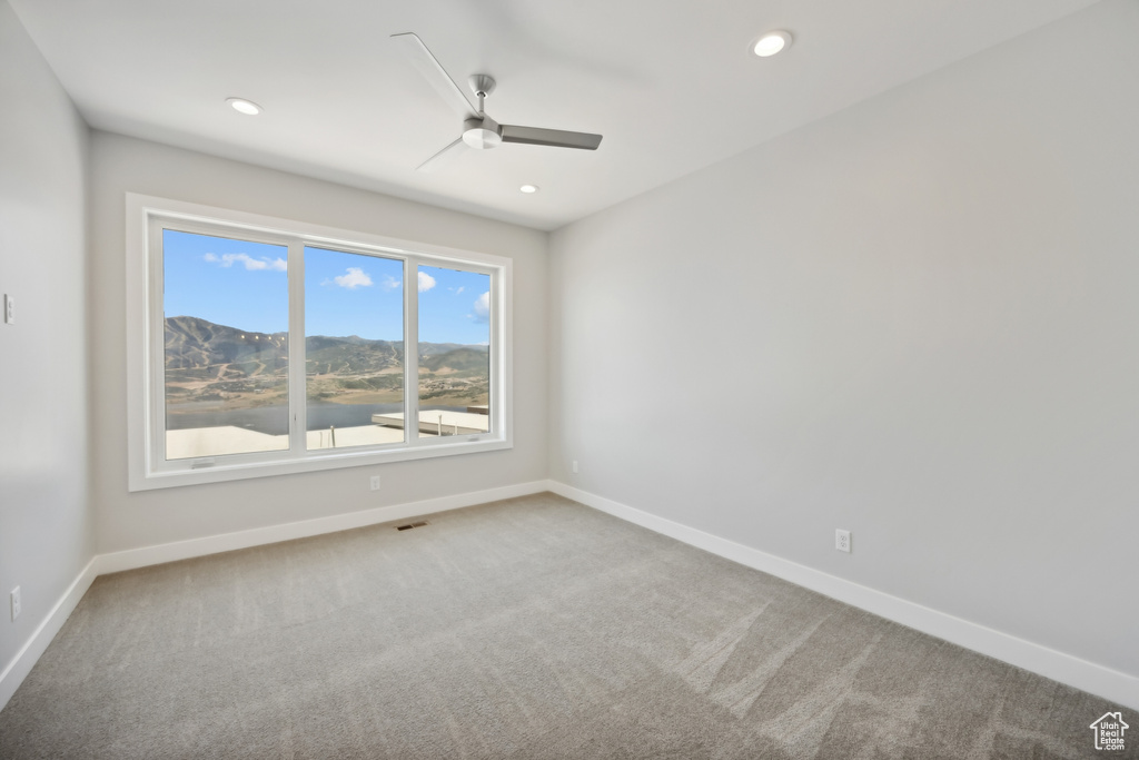 Carpeted empty room featuring ceiling fan