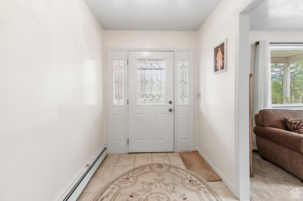 Foyer with baseboard heating and light tile patterned floors