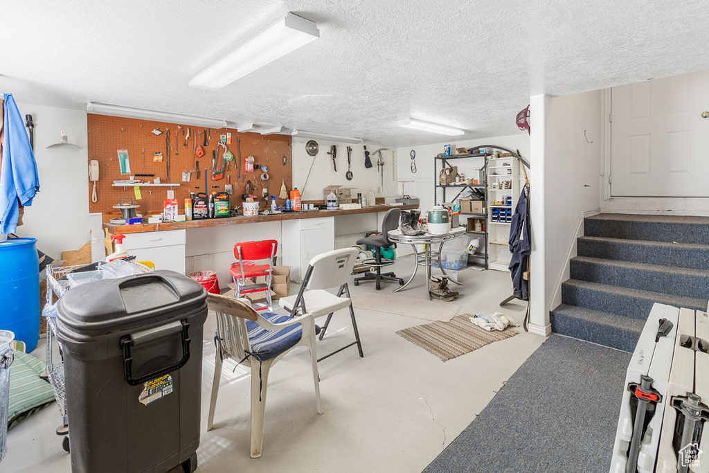 Basement with a textured ceiling and a workshop area