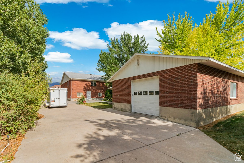 View of side of home with a garage and an outbuilding