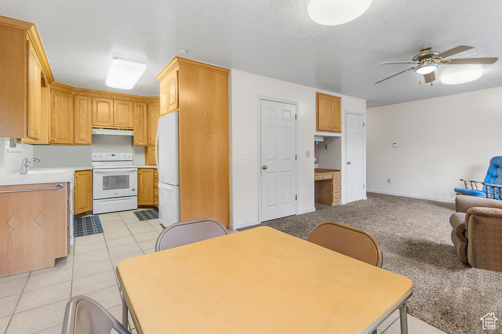 Kitchen featuring sink, ceiling fan, white appliances, and light tile patterned floors