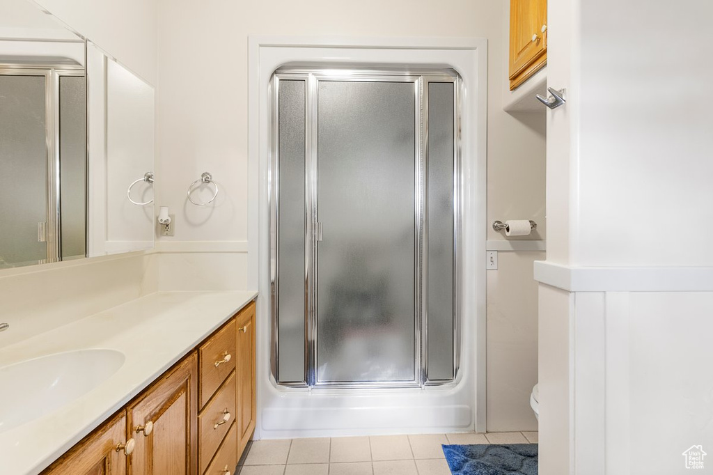 Bathroom featuring vanity, tile patterned flooring, and toilet