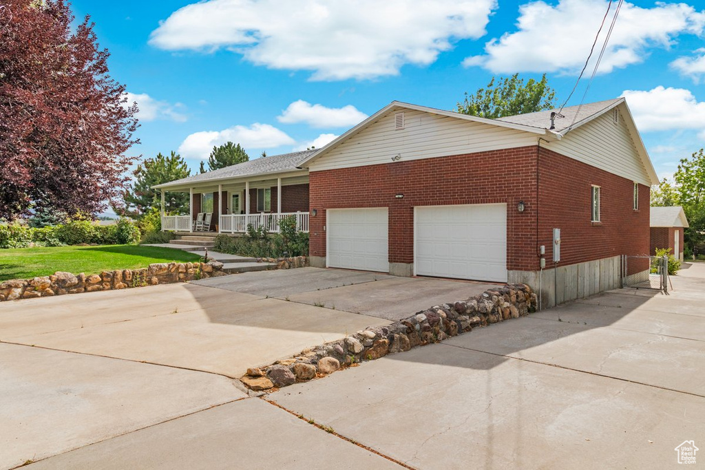 View of front of property featuring a porch and a garage