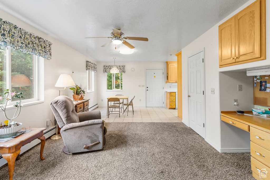 Interior space featuring ceiling fan, a wealth of natural light, and baseboard heating