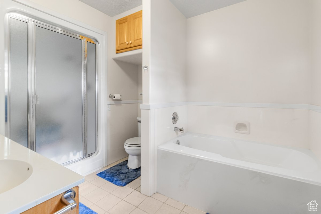 Full bathroom featuring tile patterned flooring, independent shower and bath, toilet, and vanity